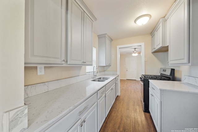 kitchen with dark hardwood / wood-style flooring, white cabinetry, sink, and black range with gas cooktop