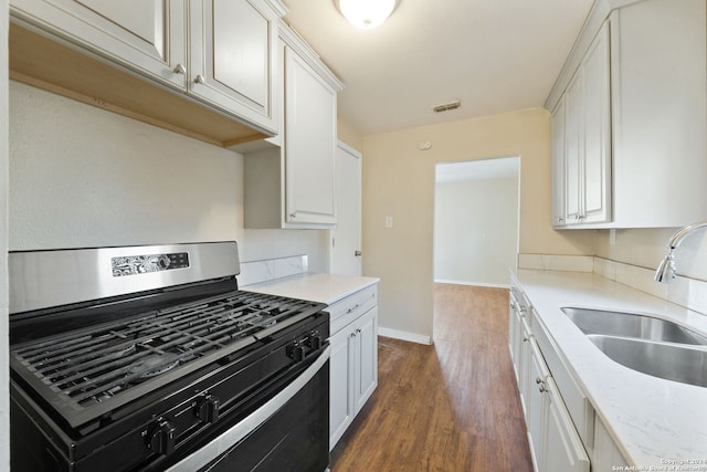 kitchen with gas stove, white cabinetry, sink, and dark wood-type flooring