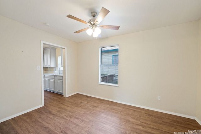 empty room featuring hardwood / wood-style flooring, ceiling fan, and sink