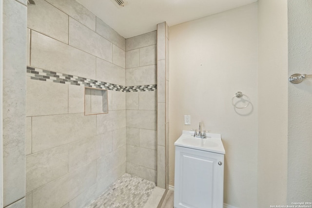 bathroom with vanity and tiled shower