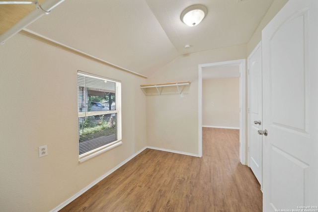 walk in closet featuring wood-type flooring and lofted ceiling