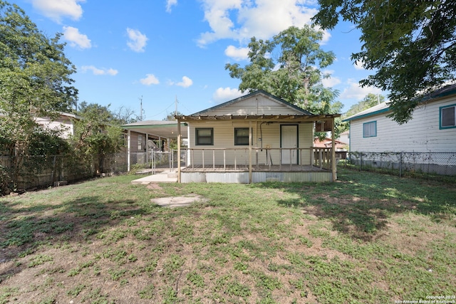 back of property with covered porch and a lawn