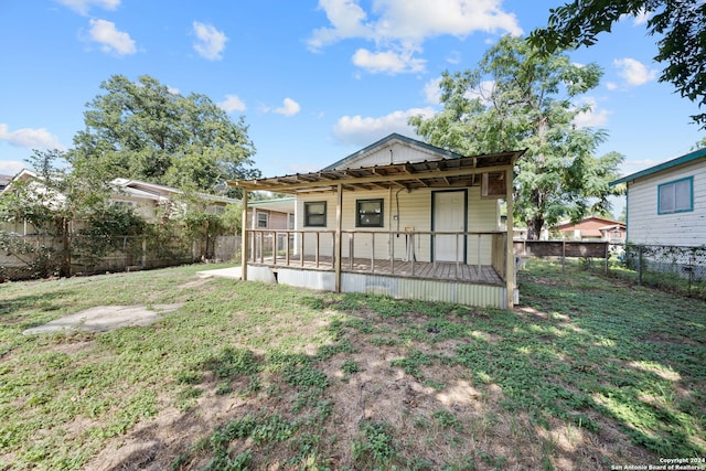 rear view of property with a lawn and a porch