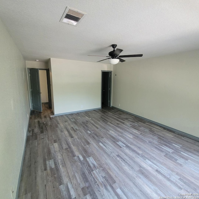 spare room with ceiling fan, wood-type flooring, and a textured ceiling