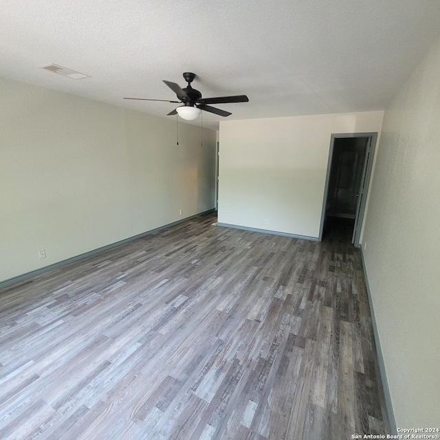 spare room featuring wood-type flooring, a textured ceiling, and ceiling fan