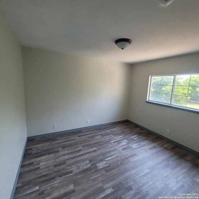 unfurnished room featuring dark wood-type flooring