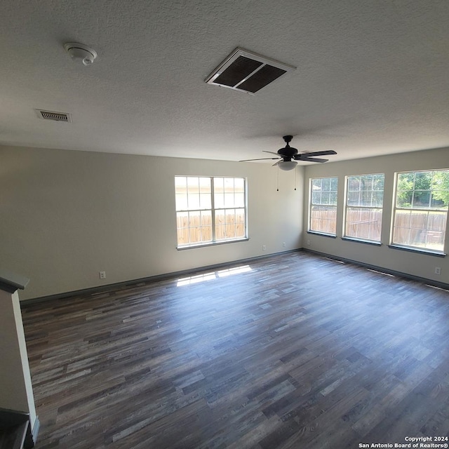 empty room featuring ceiling fan, dark hardwood / wood-style flooring, and a textured ceiling