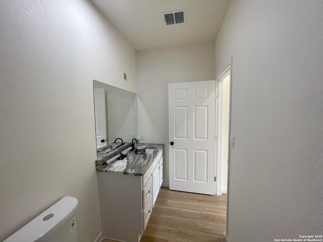 bathroom with vanity, hardwood / wood-style flooring, and toilet