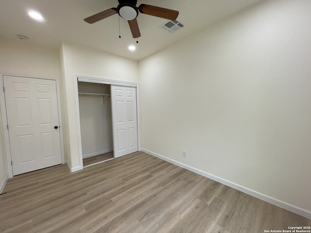 unfurnished bedroom featuring ceiling fan, a closet, and light wood-type flooring