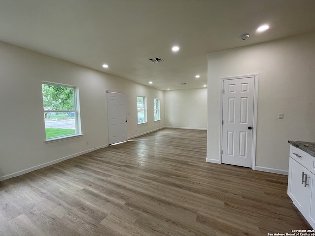 unfurnished living room with a healthy amount of sunlight and wood-type flooring