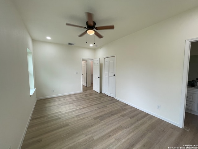 unfurnished bedroom featuring ceiling fan, connected bathroom, and light hardwood / wood-style floors