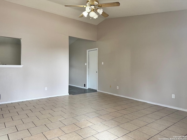 empty room with ceiling fan, baseboards, and vaulted ceiling