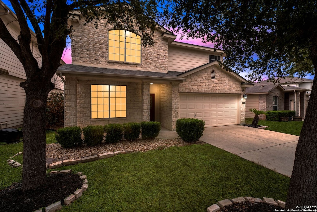 view of front of property featuring a garage and a lawn