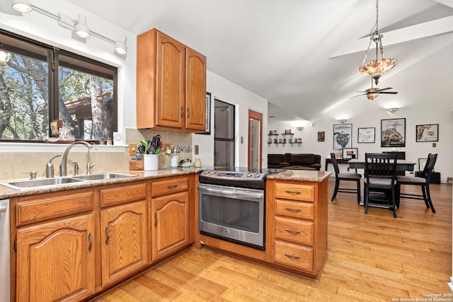 kitchen featuring sink, tasteful backsplash, light hardwood / wood-style floors, vaulted ceiling, and appliances with stainless steel finishes