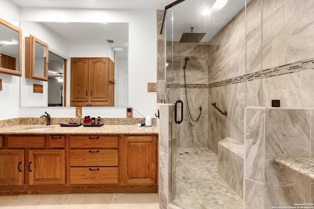 bathroom featuring a shower with door and vanity