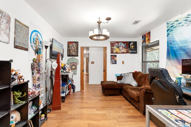 living room with a notable chandelier and light hardwood / wood-style floors