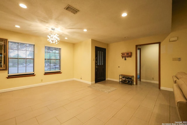 unfurnished living room with an inviting chandelier