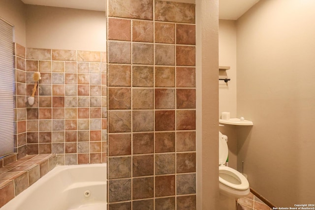 bathroom with toilet and tiled shower / bath