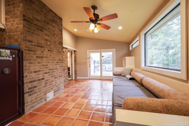 tiled living room featuring ceiling fan and lofted ceiling