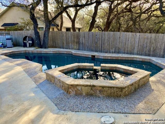 view of swimming pool with an in ground hot tub