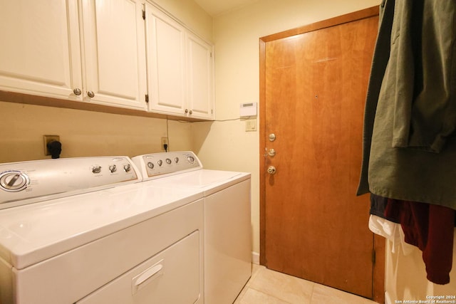 washroom featuring washer and clothes dryer, light tile patterned flooring, and cabinets