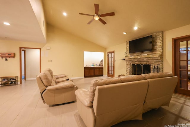 living room with a stone fireplace, ceiling fan, and high vaulted ceiling