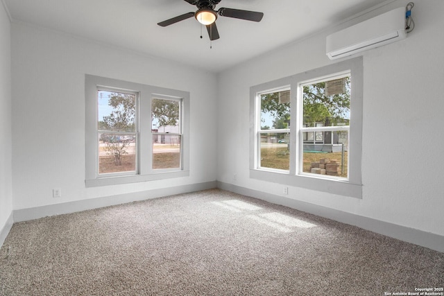 spare room featuring a wall unit AC, carpet floors, a wealth of natural light, and ceiling fan