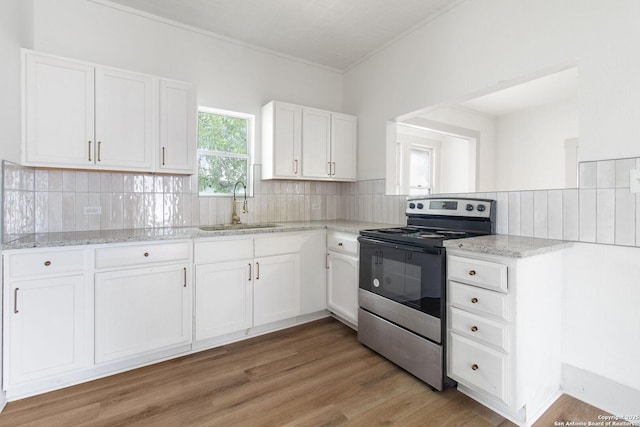 kitchen featuring white cabinets, sink, backsplash, and stainless steel electric range