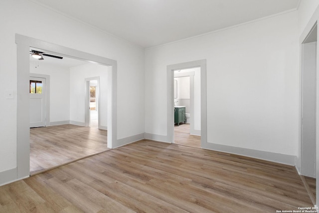 spare room with light wood-type flooring, ceiling fan, and ornamental molding