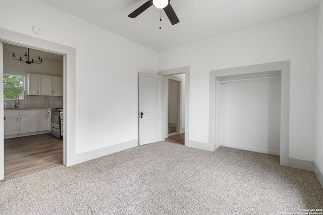 unfurnished bedroom with ceiling fan, light carpet, and a closet