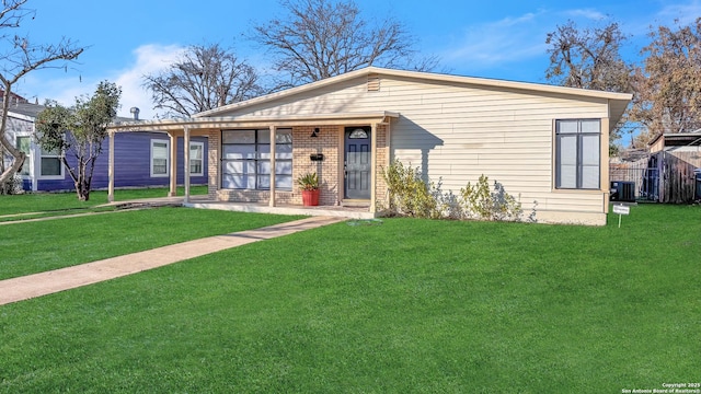 view of front of home with cooling unit and a front lawn