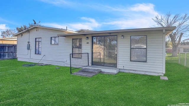 rear view of property featuring a yard