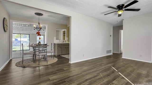 unfurnished dining area with ceiling fan with notable chandelier, dark hardwood / wood-style floors, and sink