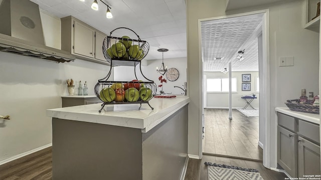 kitchen featuring gray cabinets, dark hardwood / wood-style flooring, and hanging light fixtures