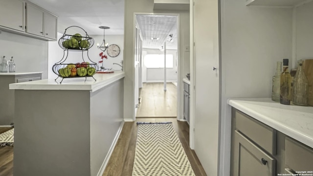 kitchen featuring gray cabinetry, decorative light fixtures, and dark hardwood / wood-style floors