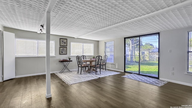 dining space featuring brick ceiling and dark hardwood / wood-style flooring