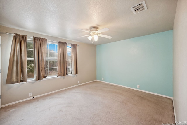 carpeted spare room featuring a textured ceiling and ceiling fan