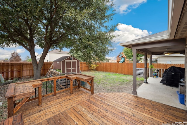 wooden deck featuring ceiling fan, a storage shed, and a lawn