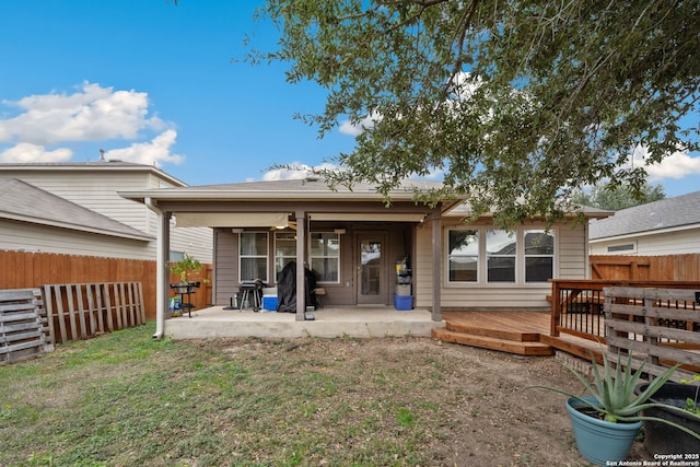 rear view of property featuring a yard and a wooden deck