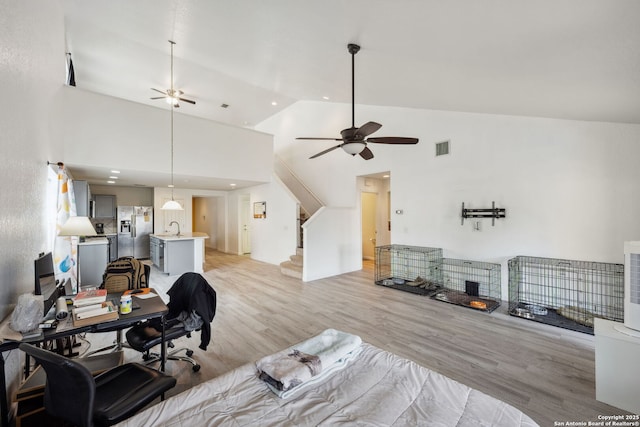 living room with high vaulted ceiling, light hardwood / wood-style flooring, ceiling fan, and sink