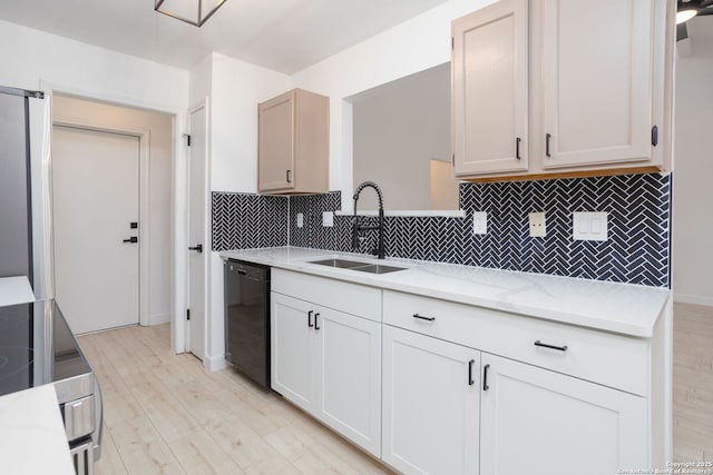 kitchen with white cabinets, decorative backsplash, black dishwasher, and sink