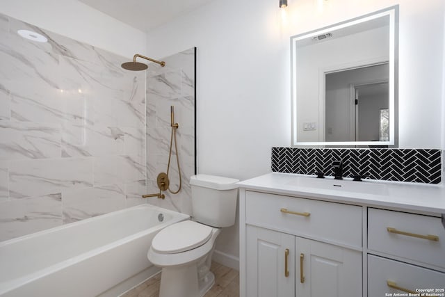 full bathroom featuring vanity, tiled shower / bath, hardwood / wood-style flooring, toilet, and tasteful backsplash