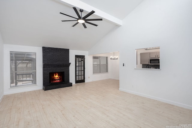 unfurnished living room with light wood-type flooring, a fireplace, ceiling fan, high vaulted ceiling, and beamed ceiling