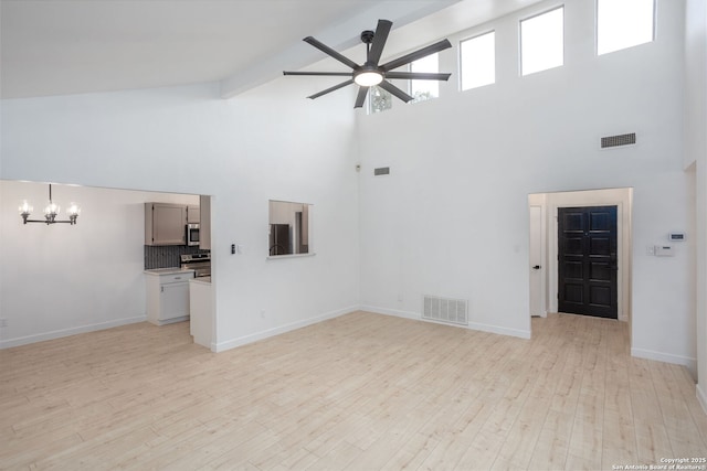 unfurnished living room featuring beam ceiling, light hardwood / wood-style flooring, high vaulted ceiling, and ceiling fan with notable chandelier