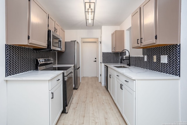 kitchen with white cabinets, light stone counters, sink, and stainless steel appliances