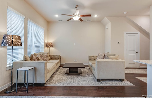 living room with ceiling fan and dark wood-type flooring