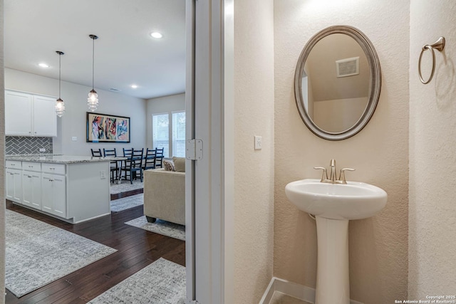 bathroom featuring decorative backsplash and hardwood / wood-style floors