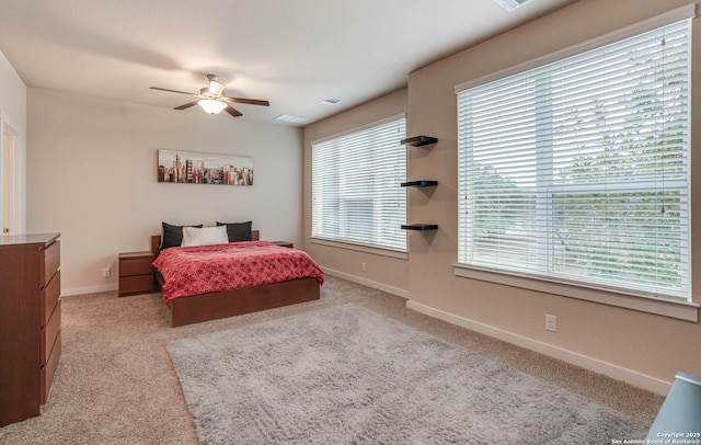 bedroom with multiple windows, light carpet, and ceiling fan