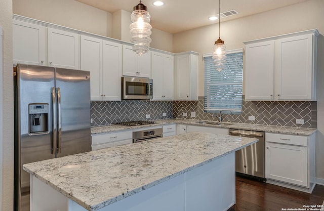 kitchen featuring white cabinets, pendant lighting, and appliances with stainless steel finishes