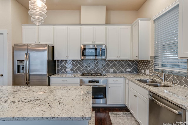 kitchen with white cabinets, decorative light fixtures, and stainless steel appliances